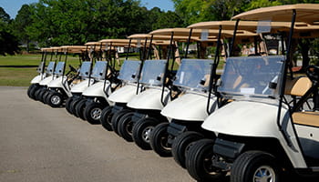 Golf carts lined up for a golf tournament.