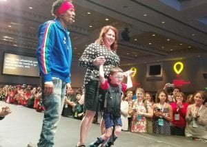 Logan Parker walks with his mom at the CMN Conference