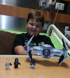 Luke Edmunds plays with Star Wars toys in the hospital