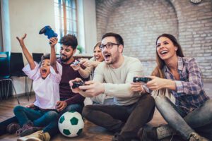Two couples play video games with their children, having fun.