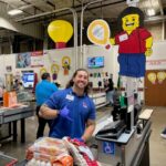 Sales associate at register gives thumbs up in Costco