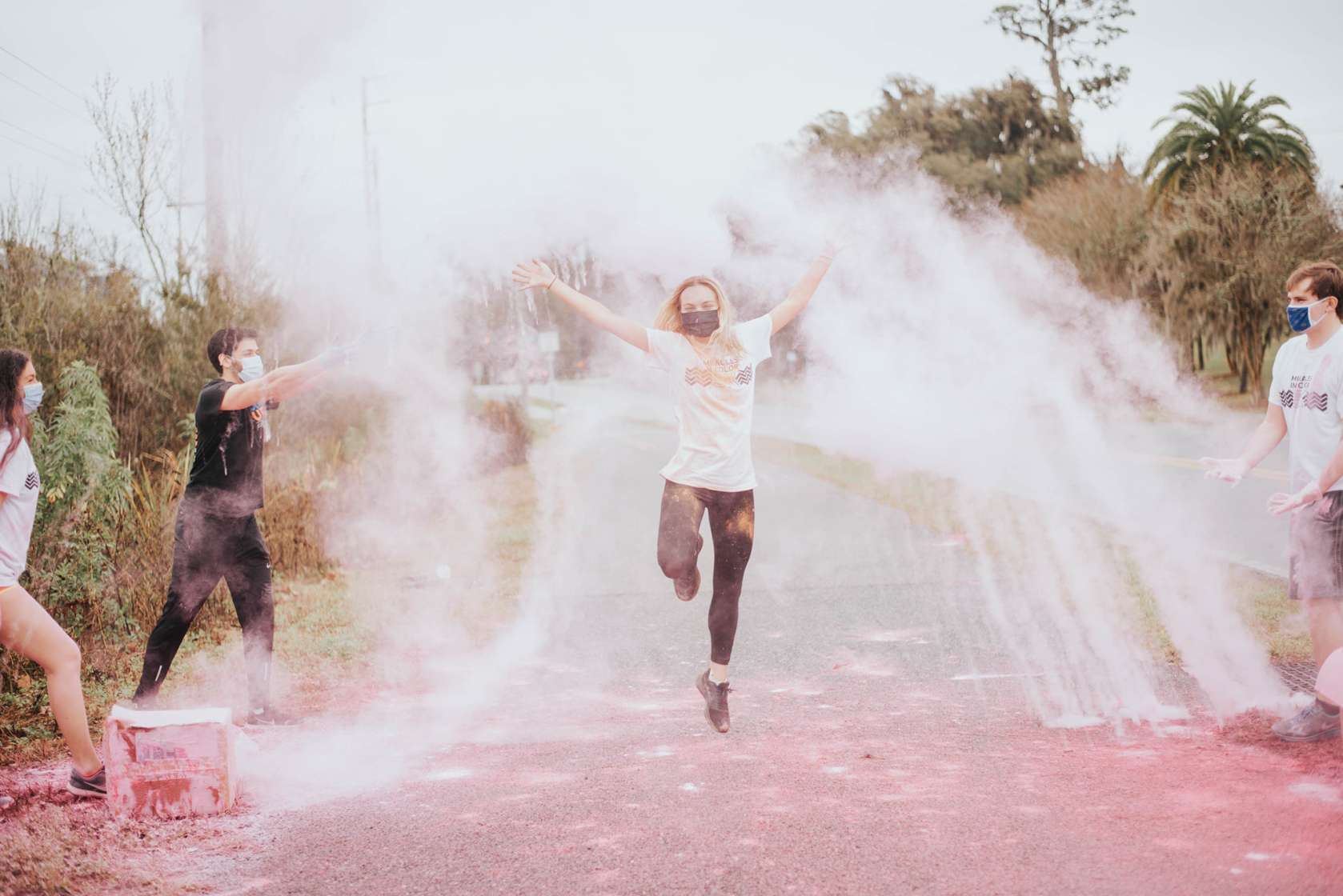 A participant runs through powdered color at the Miracles in Color 5K.