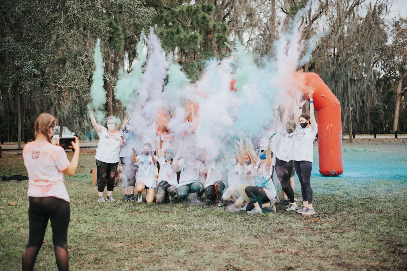 Participants throw powdered color while posing for a photo.