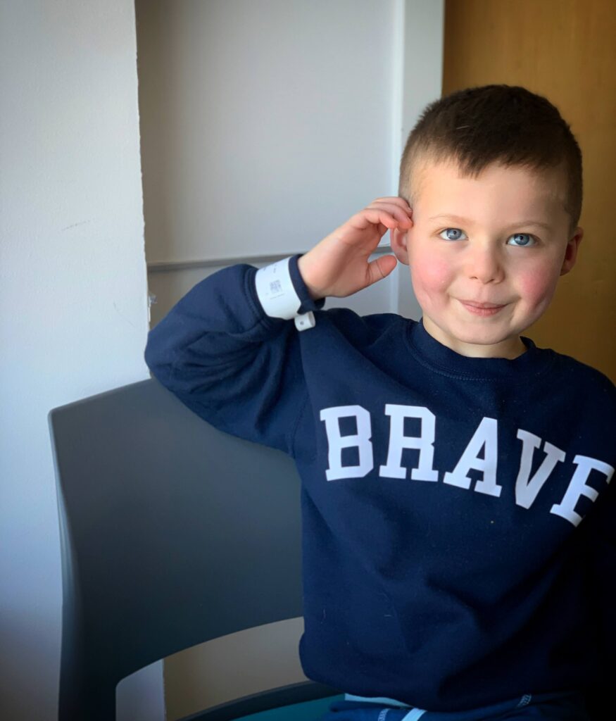 Henry posting in sweatshirt that says "BRAVE"