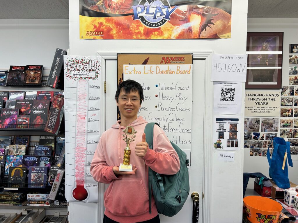 Winner of the Magic: The Gathering tournament holding a trophy