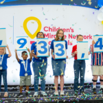 Arkansas Children's ambassadors hold up numbers to reveal amount raised by CMNH partners.